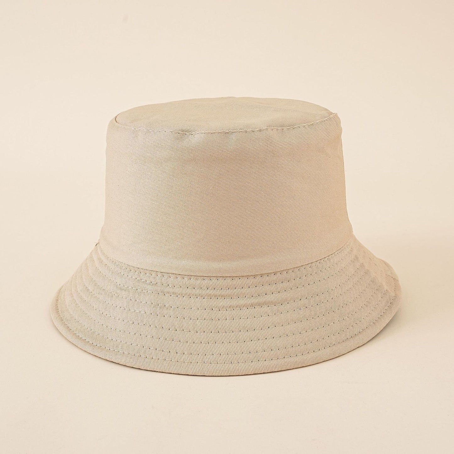 Light beige women's bucket hat with wide brim and stitched eyelet band