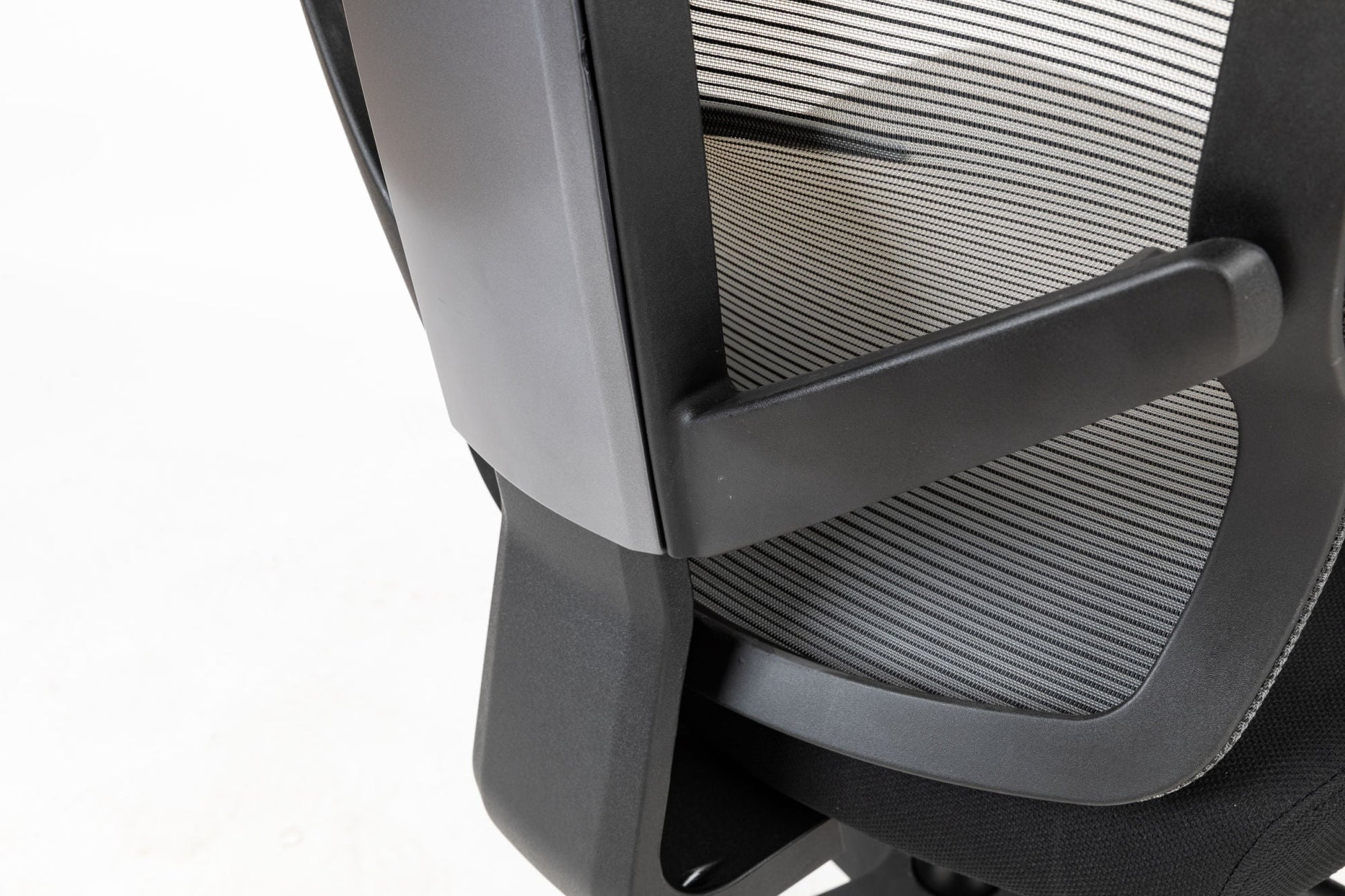Black office chair close-up of side mesh back and molded armrest