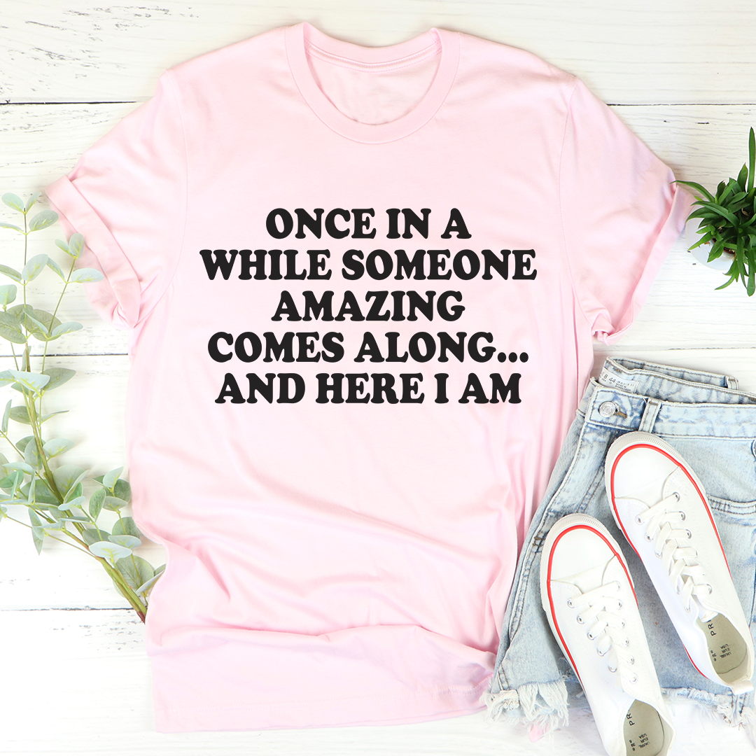 Pink crewneck T-shirt with black quote "AND HERE I AM"
