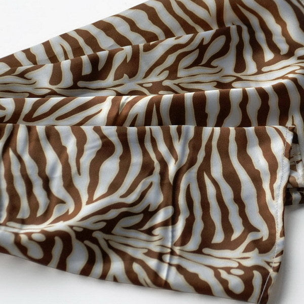 Close-up of brown and cream zebra-print silk scarf fabric folds