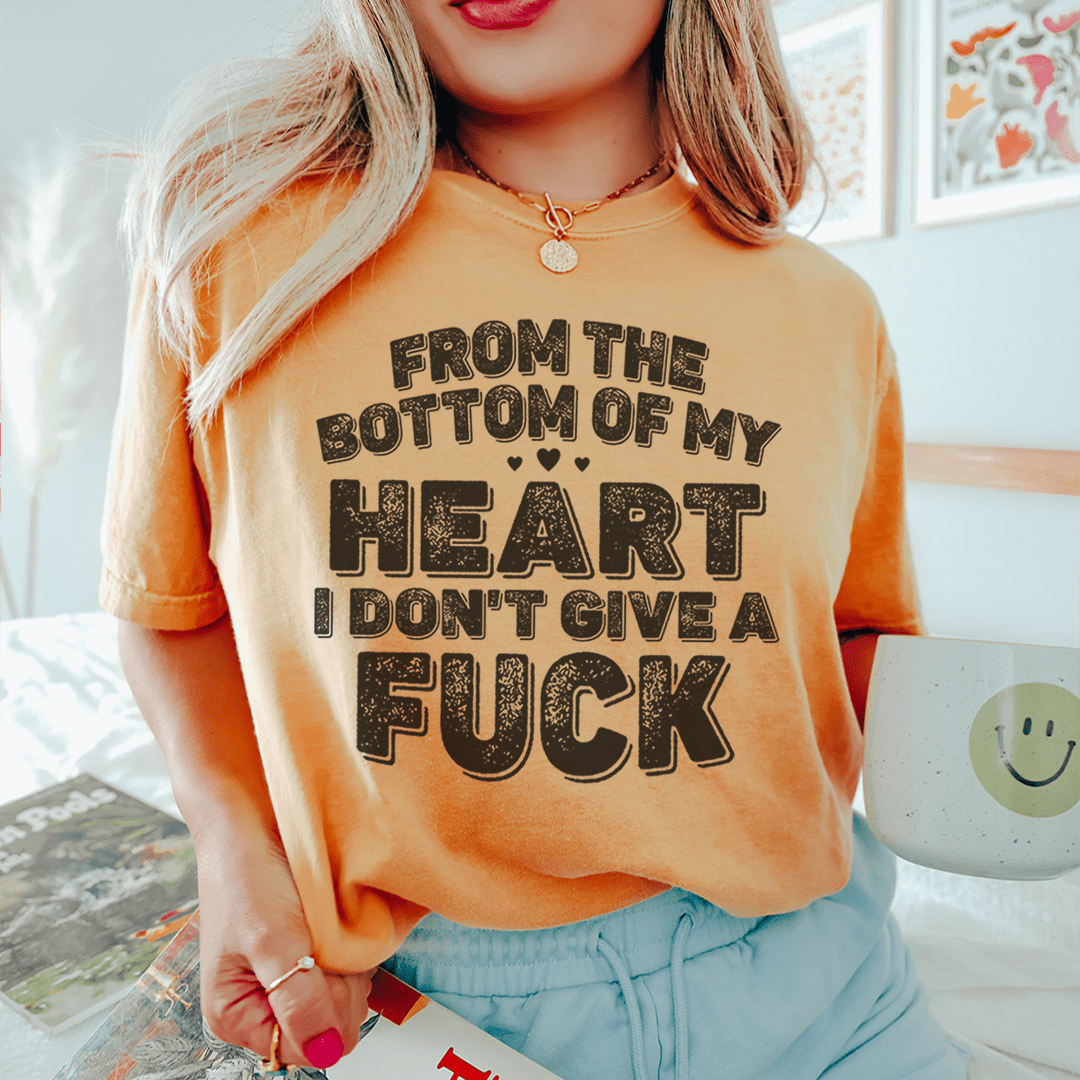 Orange T-shirt with front heart slogan graphic: 'FROM THE BOTTOM OF MY HEART' 'I DON'T GIVE A FUCK'