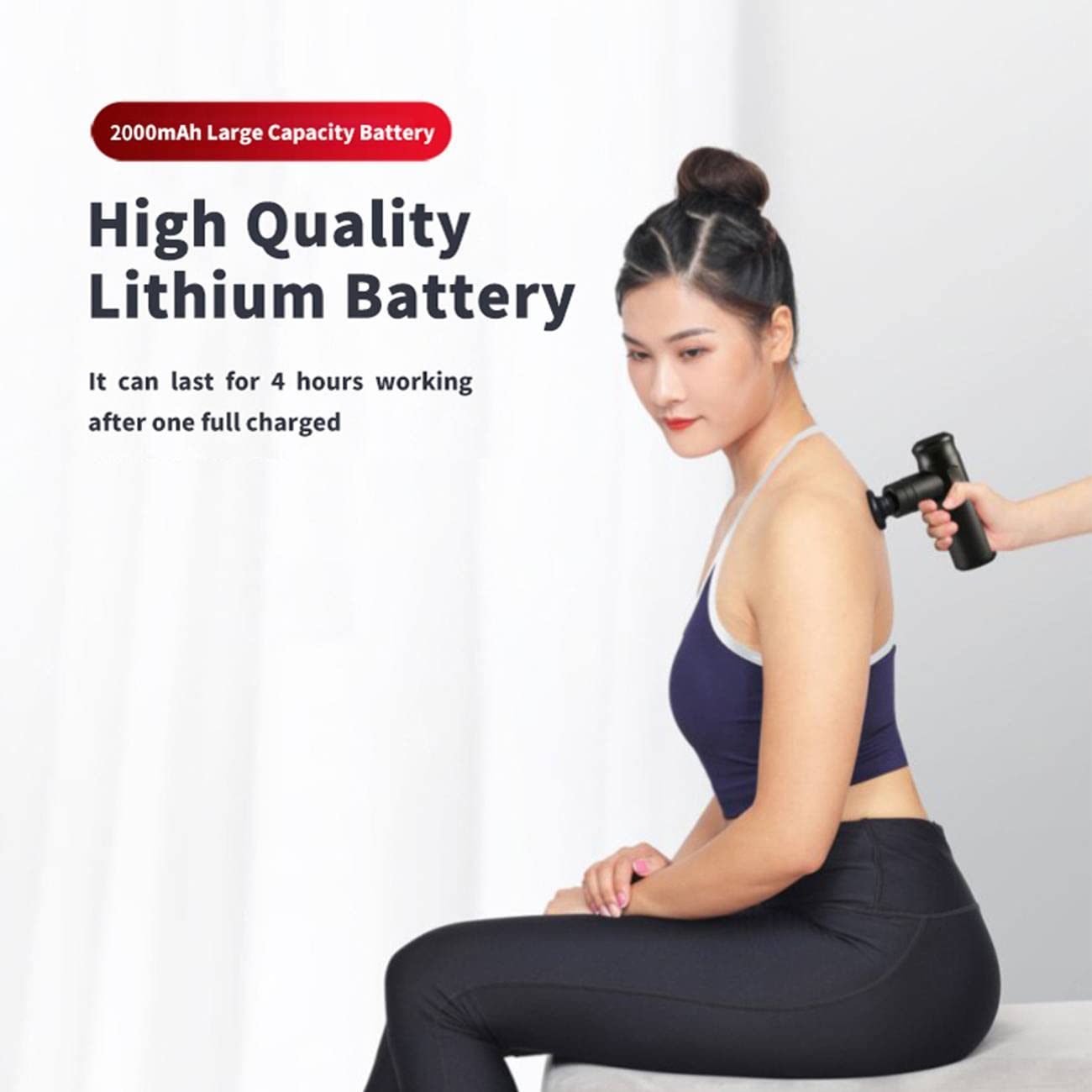 Black mini massage gun in use on a seated person’s upper body