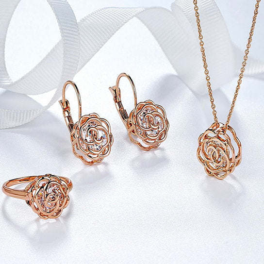 Rose gold jewelry set featuring rose-shaped earrings, ring, and pendant necklace