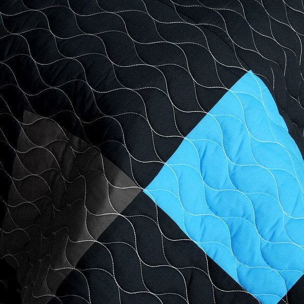Blue and black quilt patch with wavy vermicelli stitching and textured quilting