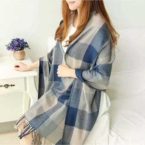 Reversible plaid shawl with blue, gray, and cream blocks; fringed edges.