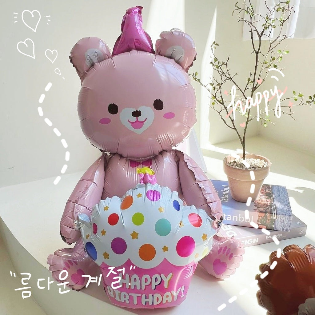 Pink bear foil balloon with party hat, smiling face, and “Happy Birthday” banner