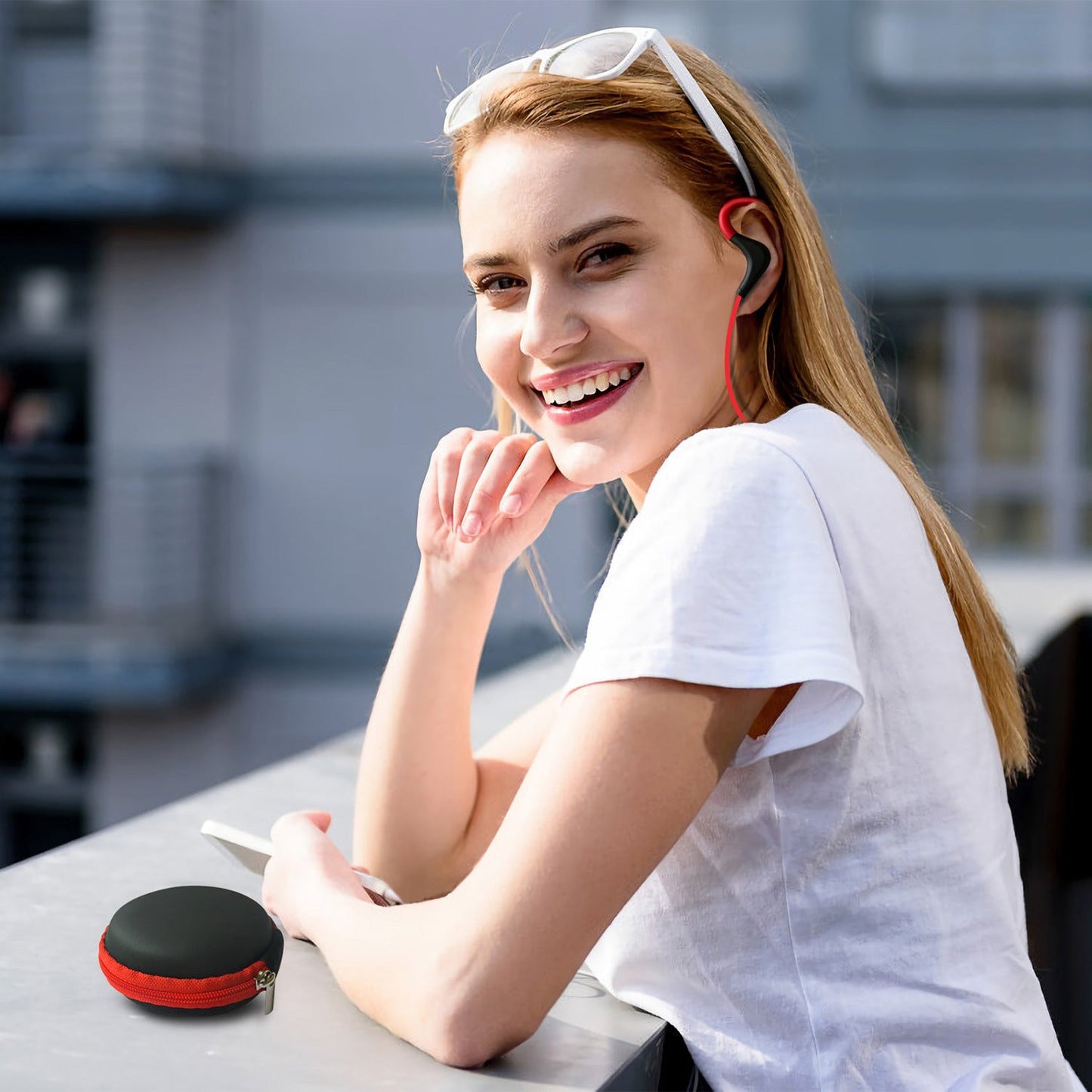 Red and black wireless in-ear headset with over-ear hook and red connecting cable