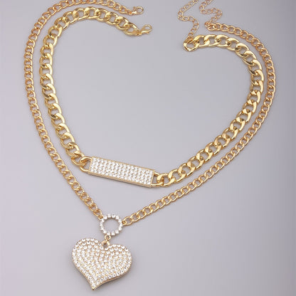 Gold double-layer necklace set with crystal bar and heart pendant on curb chains