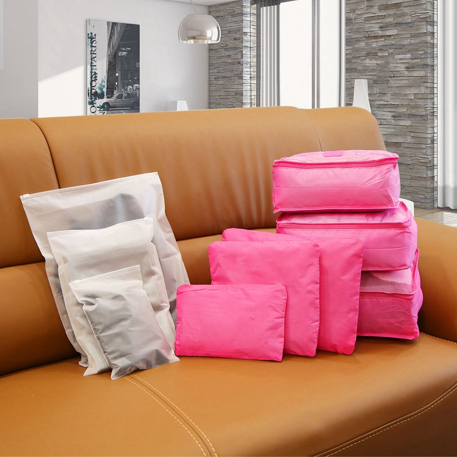Stack of pink packing cubes on a sofa with matching zip pouches