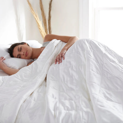 White duvet comforter spread across a bed, smooth quilted surface