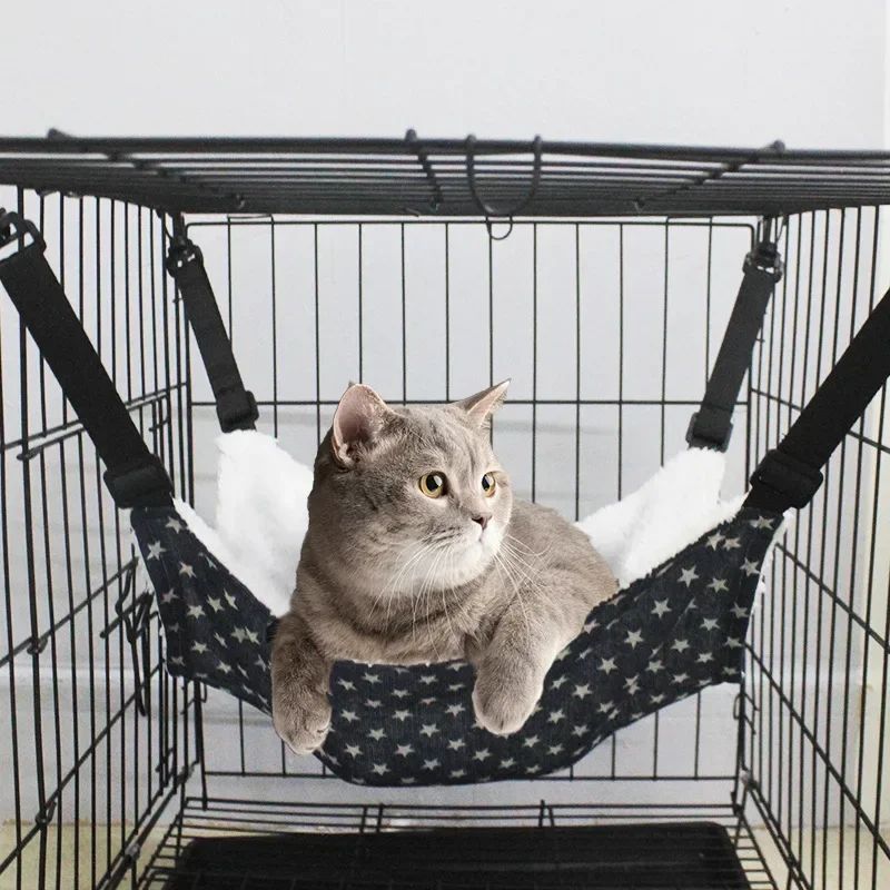 Cat hammock with dark fabric and white star pattern, suspended by black straps