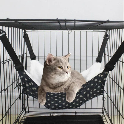 Cat hammock with dark fabric and white star pattern, suspended by black straps
