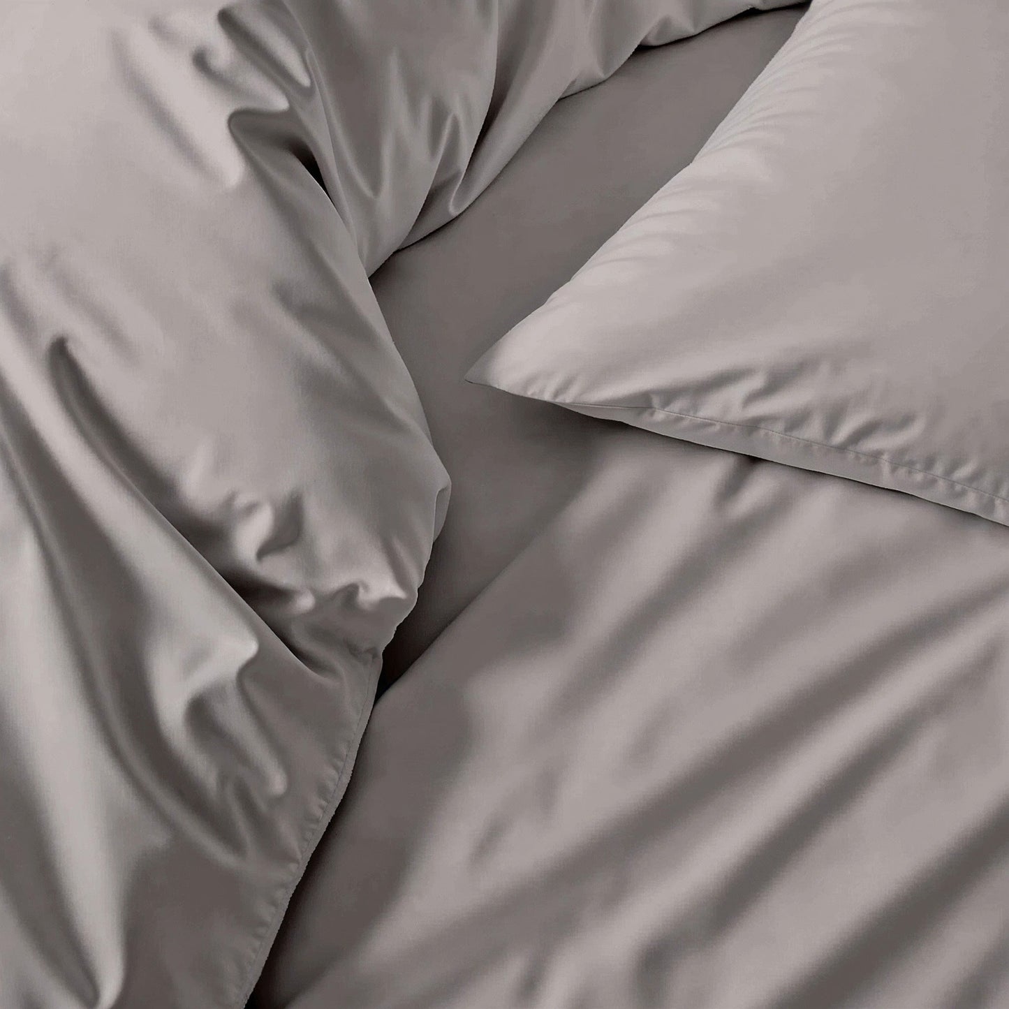 Gray sateen bedding fabric close-up with smooth, wrinkle-textured finish