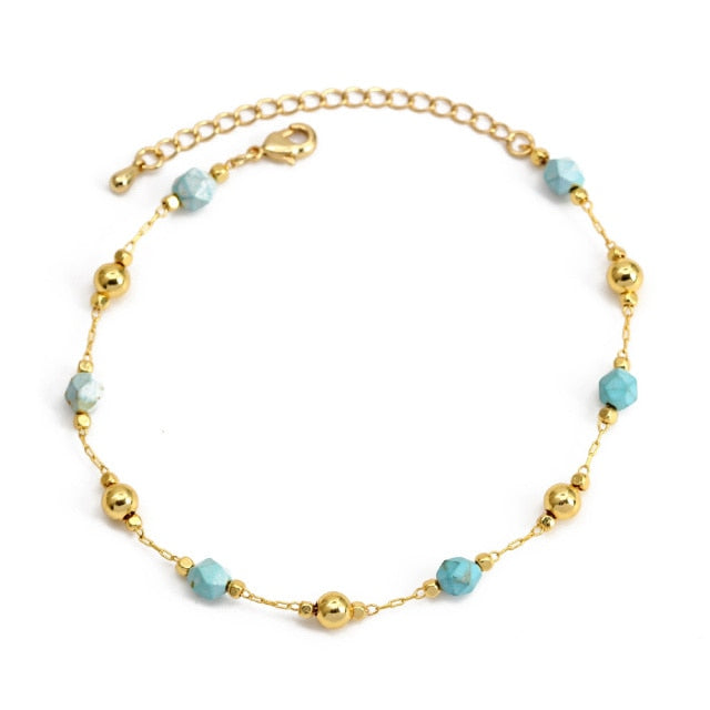 Gold charm bracelet with light blue beads and gold ball charms, secure clasp and chain