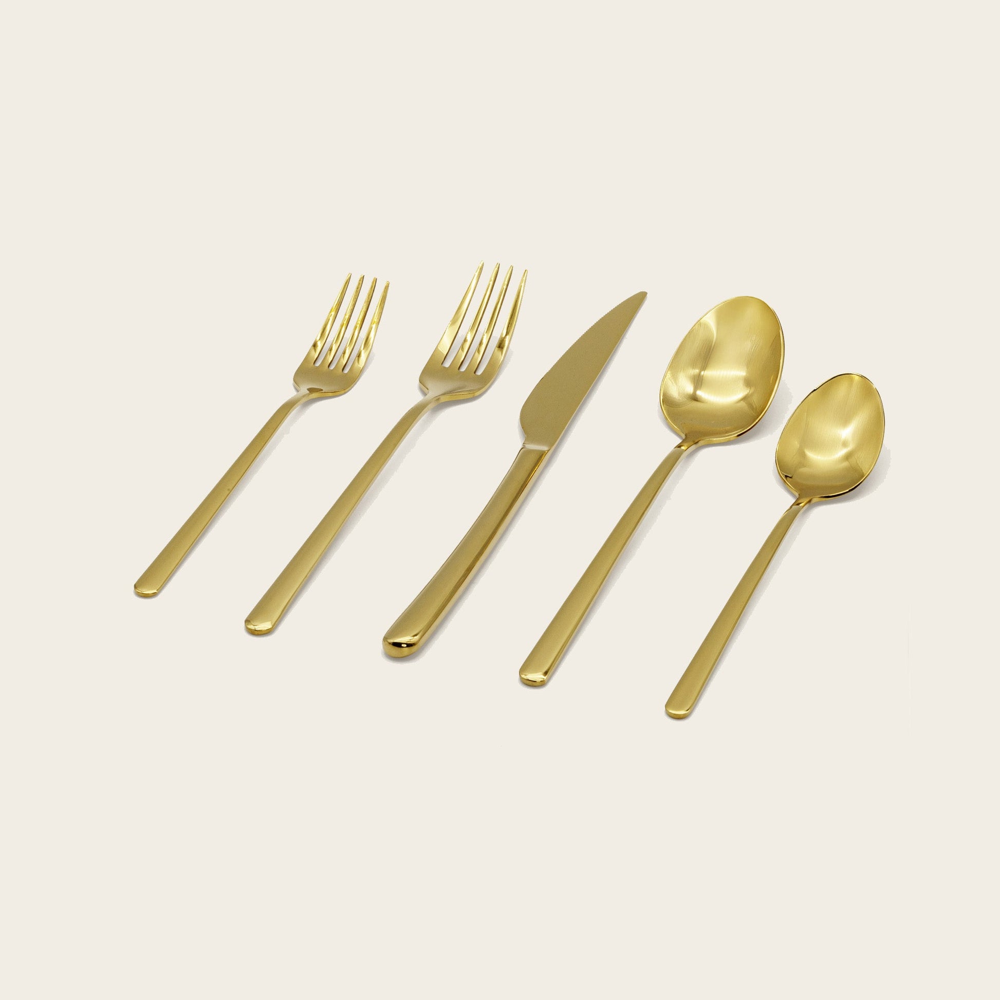Gold flatware set: forks, knife, and spoons laid out