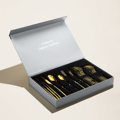 Gold flatware set in open presentation box with assorted utensil pieces