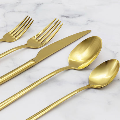 Gold flatware close-up on marble: forks, spoon, and knife