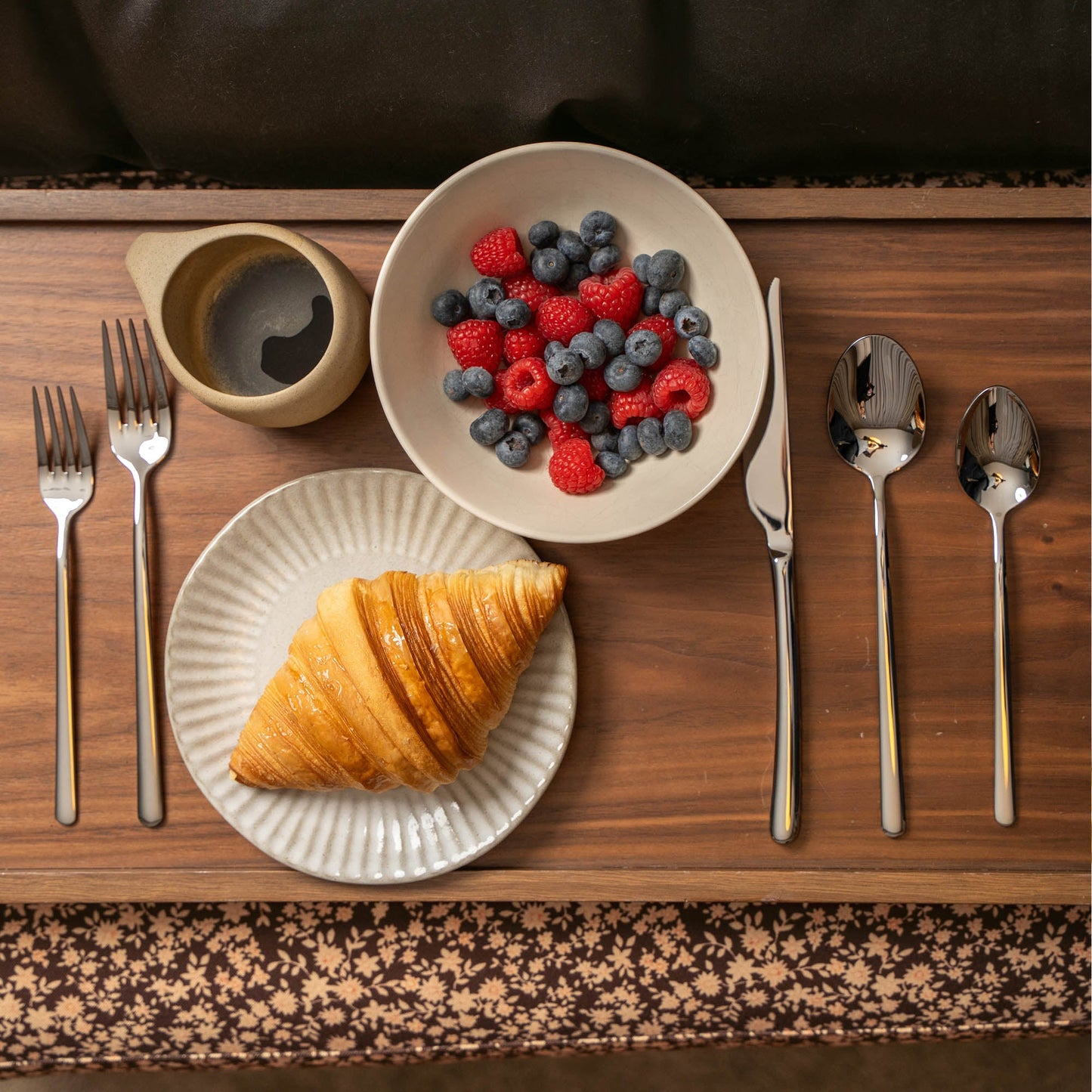 Silver flatware set with fork, knife, and spoon arranged on a tray