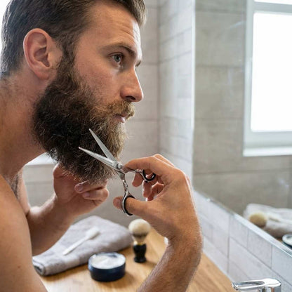 Essential shears in use, held by barber hands near beard