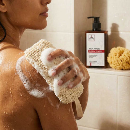 Beige exfoliating bath sponge scrubber with foam on shoulder