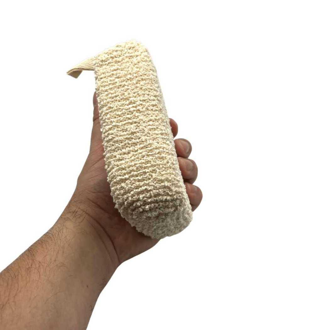 Exfoliating bath sponge scrubber held in a hand, beige textured pad