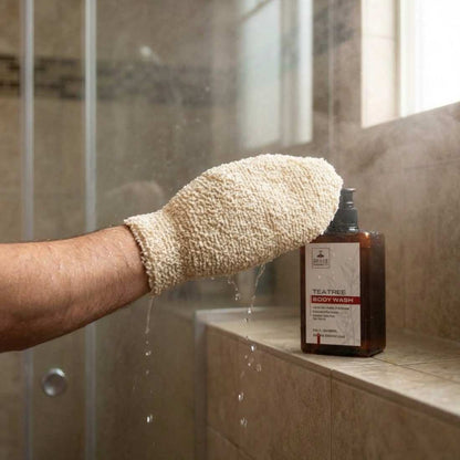 Textured beige shower mitt worn on hand, designed for exfoliating in the shower