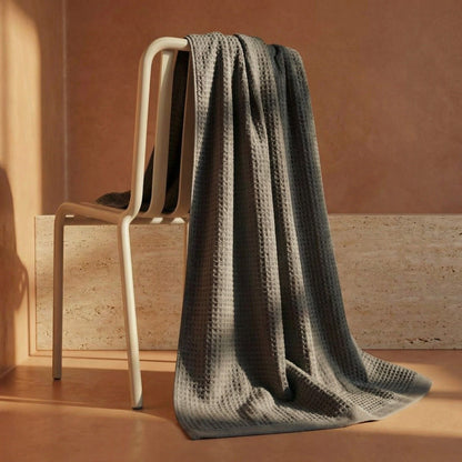 Charcoal waffle cotton towel hanging on ladder rack, textured grid weave