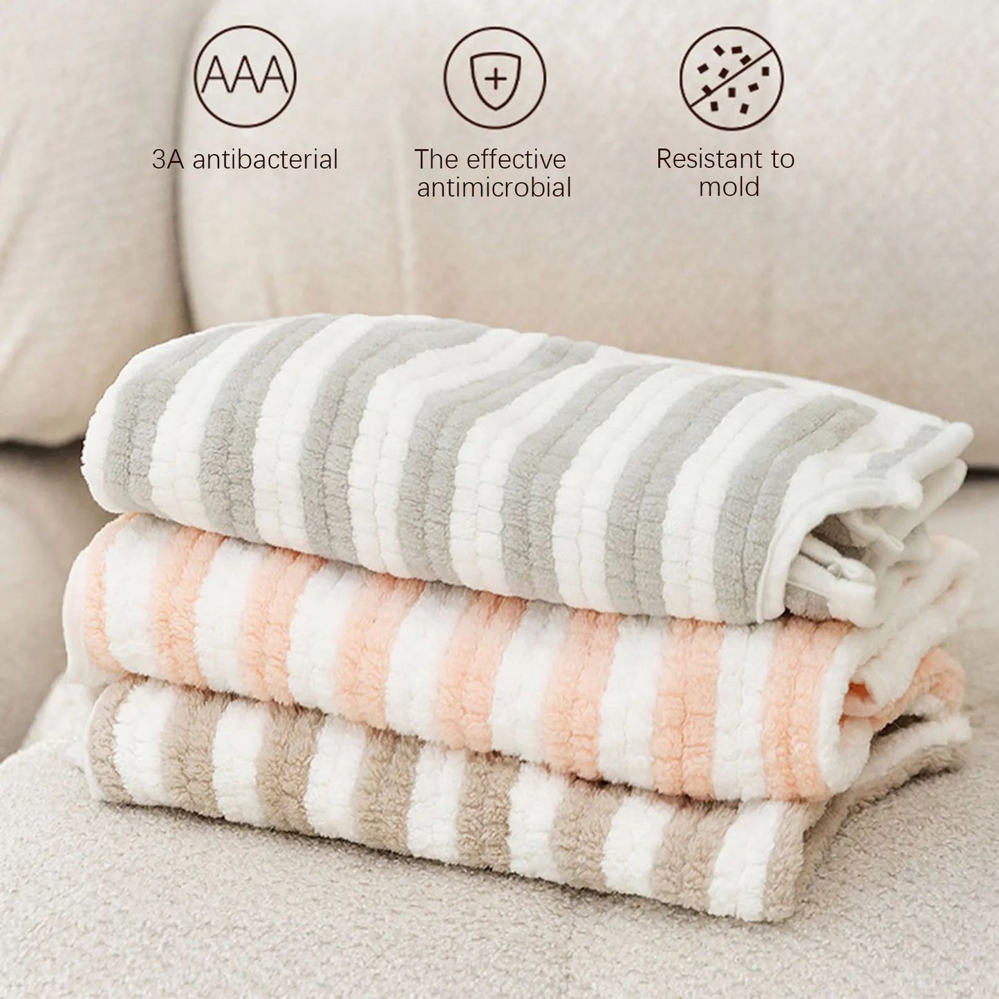 Stack of striped pet bath towels in gray, white, and peach tones