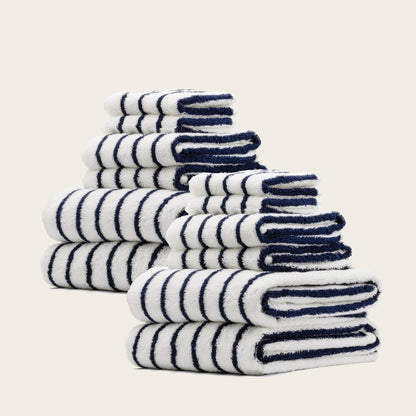 White towels with navy blue striped accents, neatly stacked with soft terry loops.