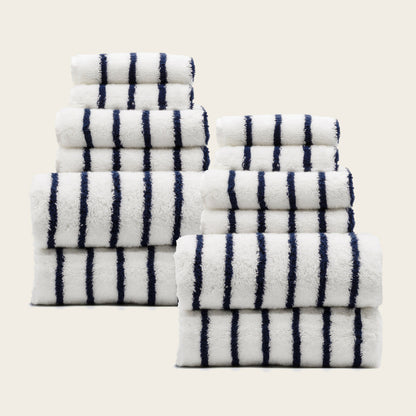Set of plush cotton towels, white with navy striped bands, neatly stacked.