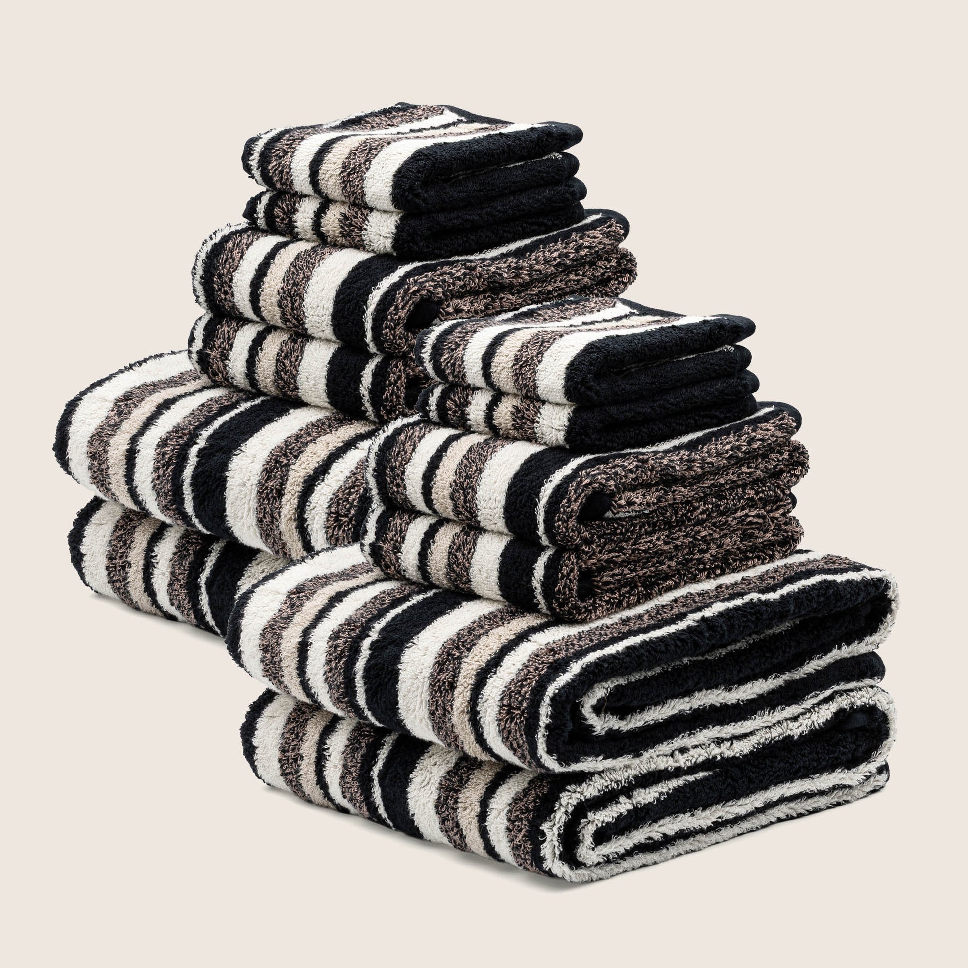 Folded striped towels, thick loop pile, with bold dark and white horizontal stripes stack.