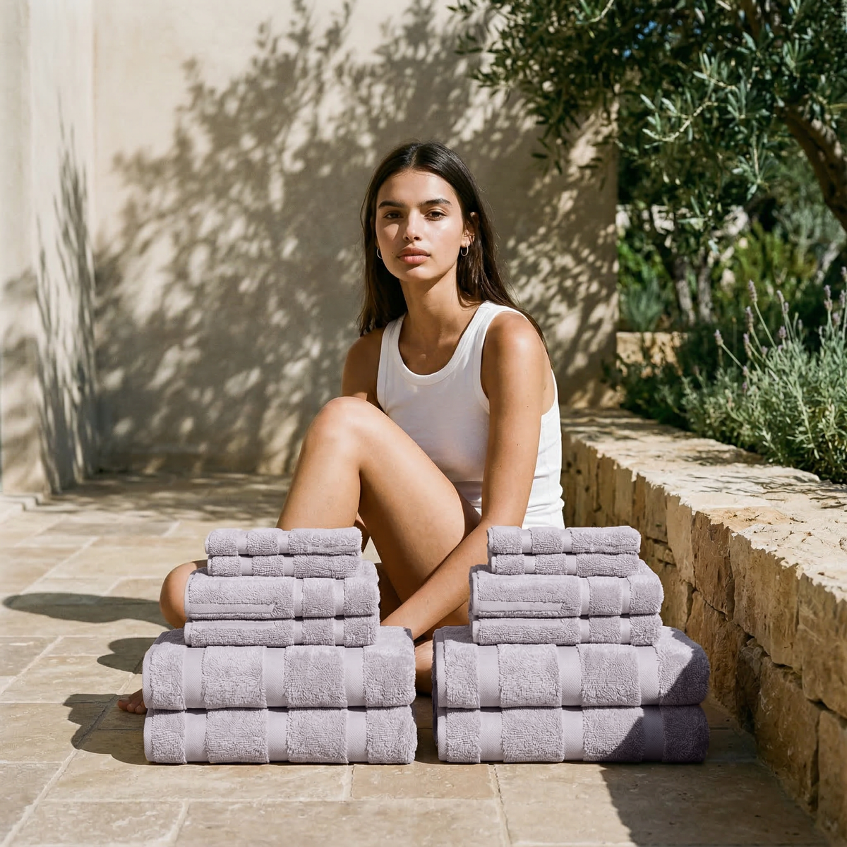 Lilac cotton towels folded into two stacks on a patio floor.