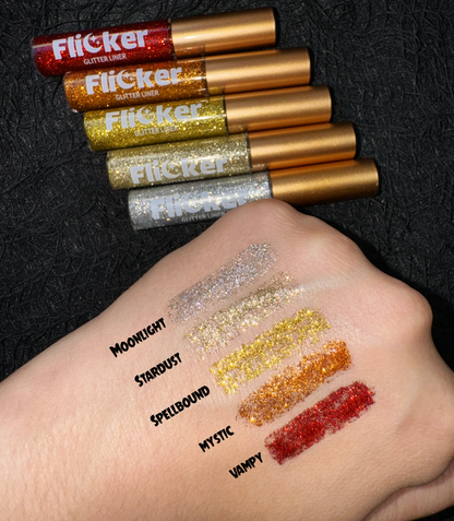Glitter eyeliner swatches on wrist showing multiple shimmering shades in stripes