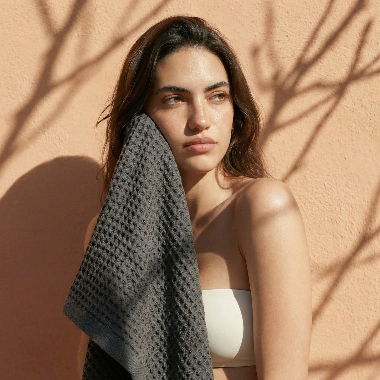 Charcoal waffle cotton towel, wrapped on shoulder with textured grid weave