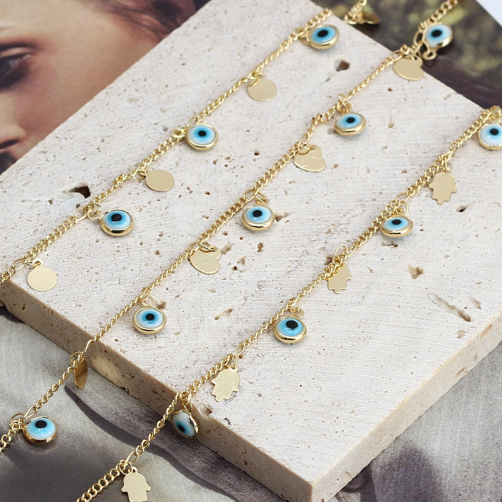Gold-tone evil-eye charm bracelet with small heart-shaped charms