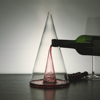 Transparent wine decanter with red wine, being filled from a bottle spout