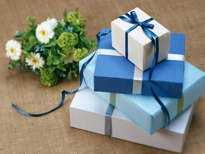 Blue and white wrapped gift boxes with ribbon bow on fabric
