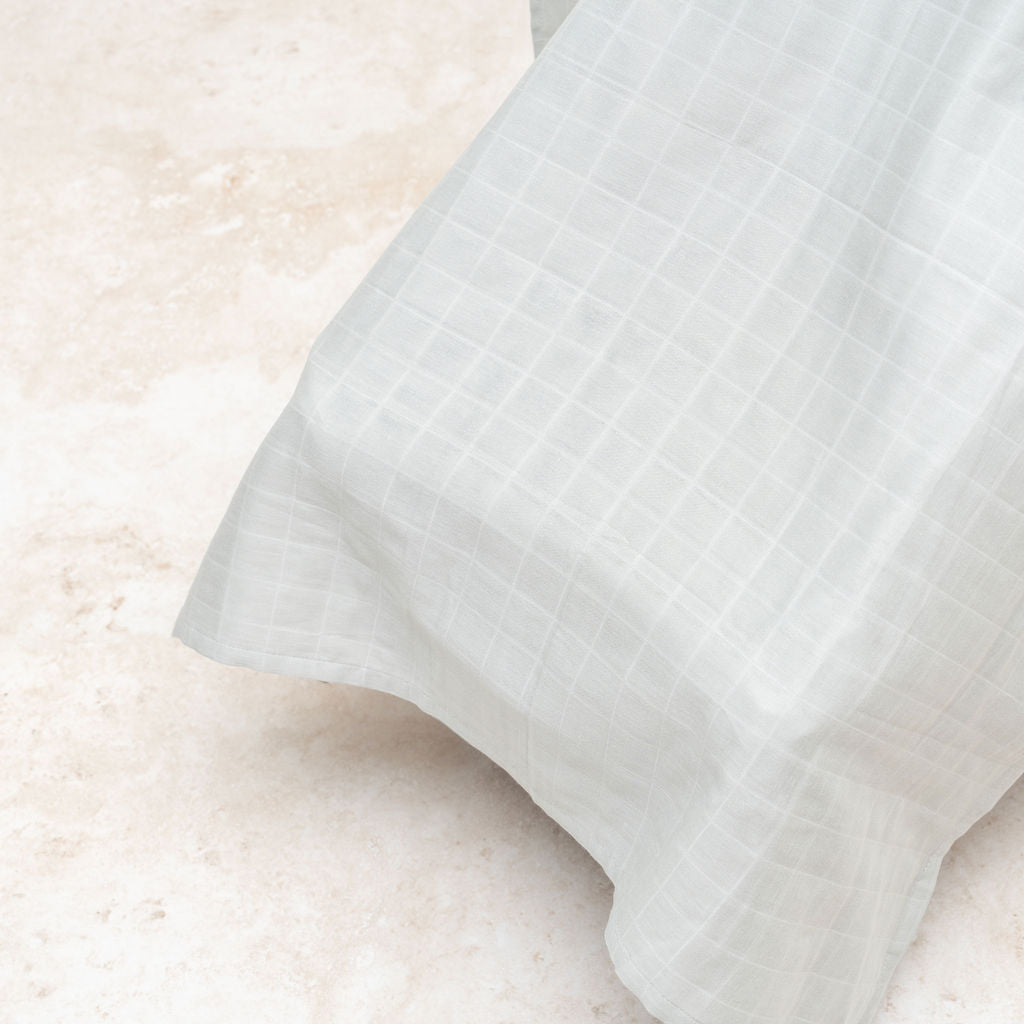 Muslin car seat cover in gray with flowing drape and textured weave
