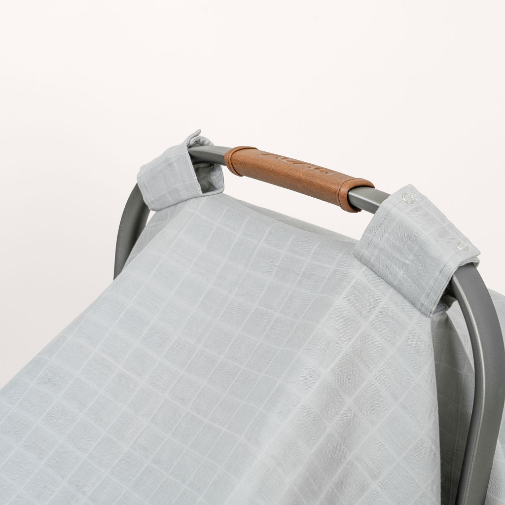 Muslin car seat cover in gray with textured weave and handle strap