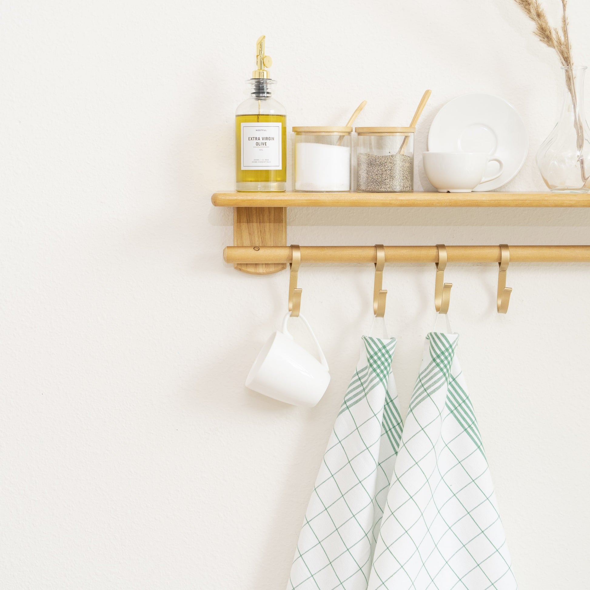 Hanging kitchen towels with green windowpane grid pattern on wall rack