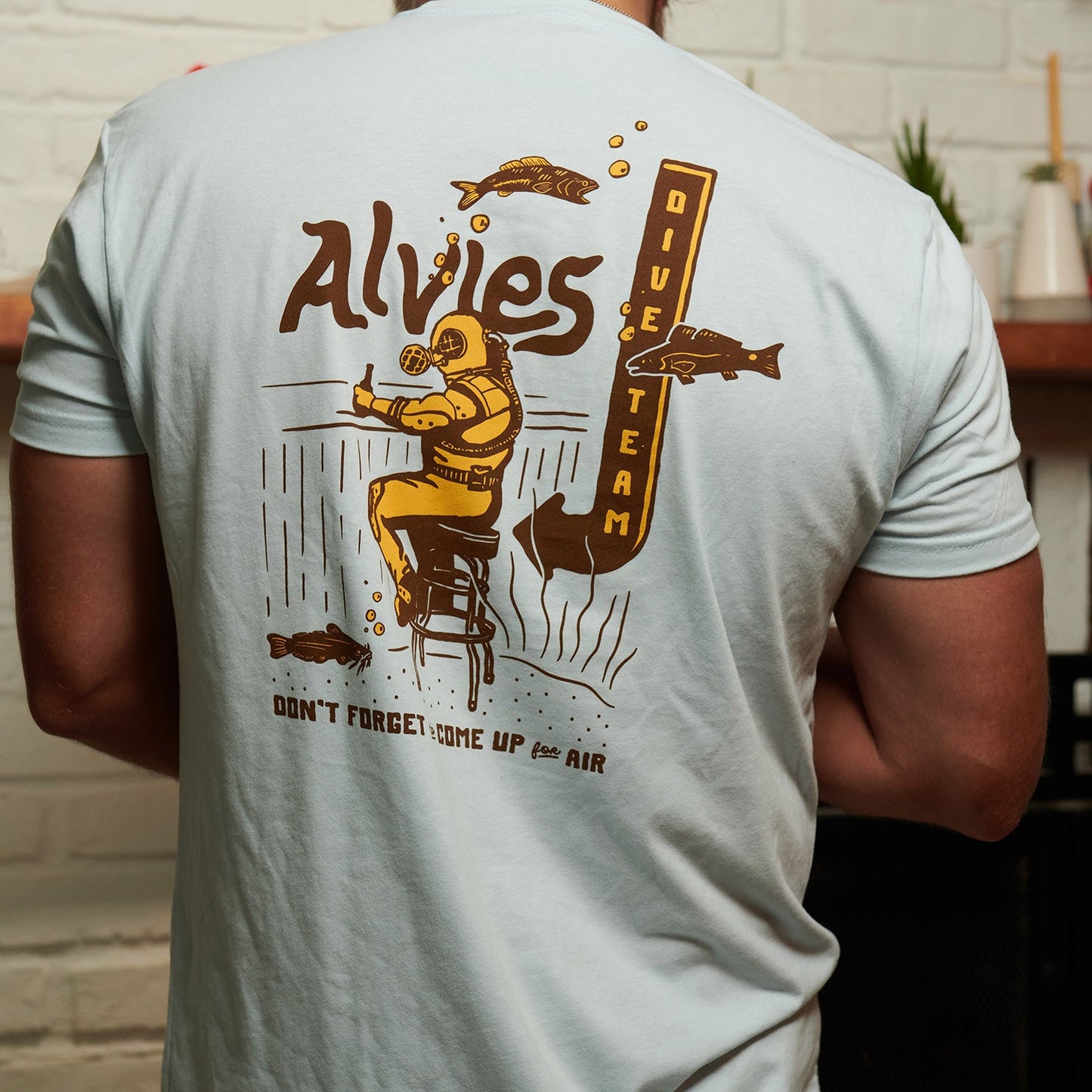 Light blue T-shirt back view with large diver graphic and vertical text