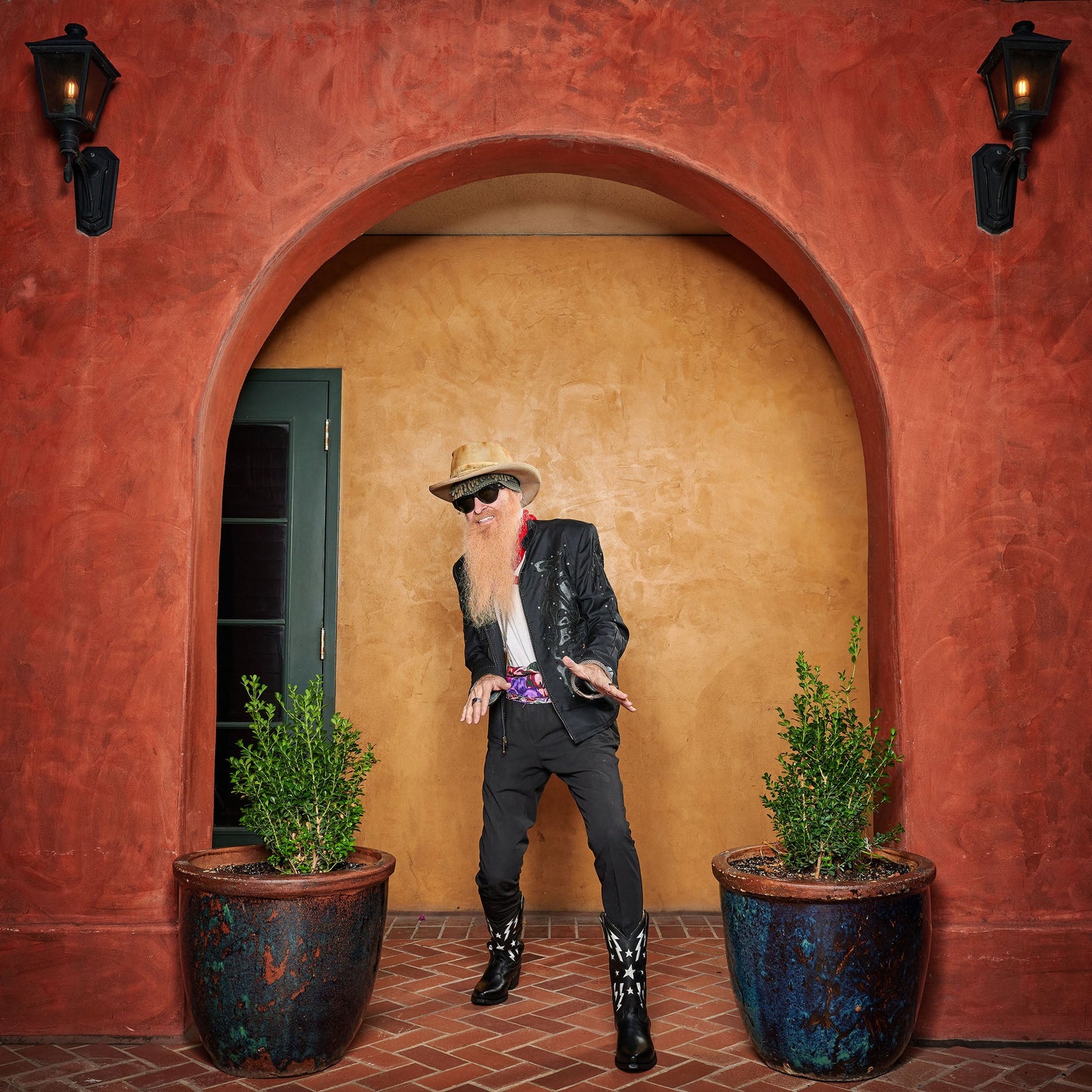Person wearing brown cowboy boots with star-and-lightning embroidery and dark pants