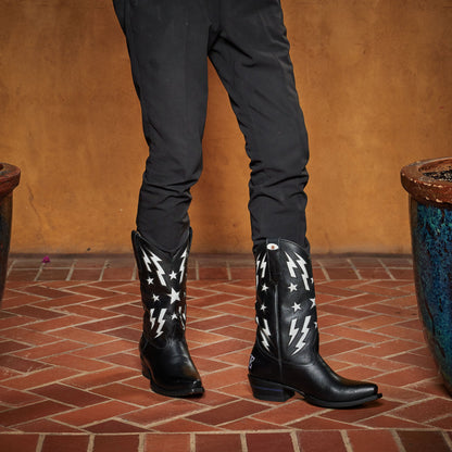 Black cowboy boots with white star and lightning patterns, worn with dark jeans