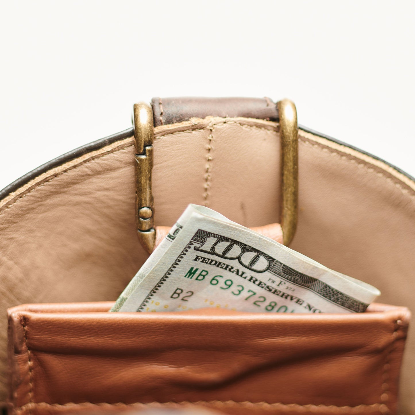Brown leather boot mule with brass buckle and tan lining; cash in front pocket