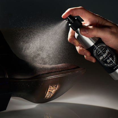 No Nasty leather cleaner spray bottle applying mist to dark leather