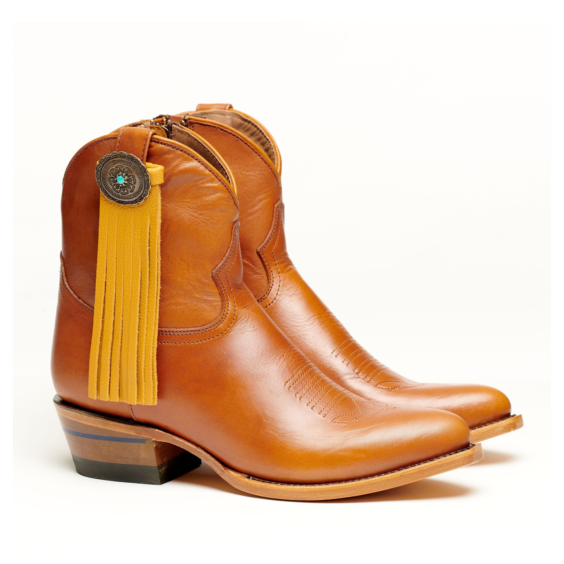 Brown leather boot with long yellow fringe tassel and concho medallion