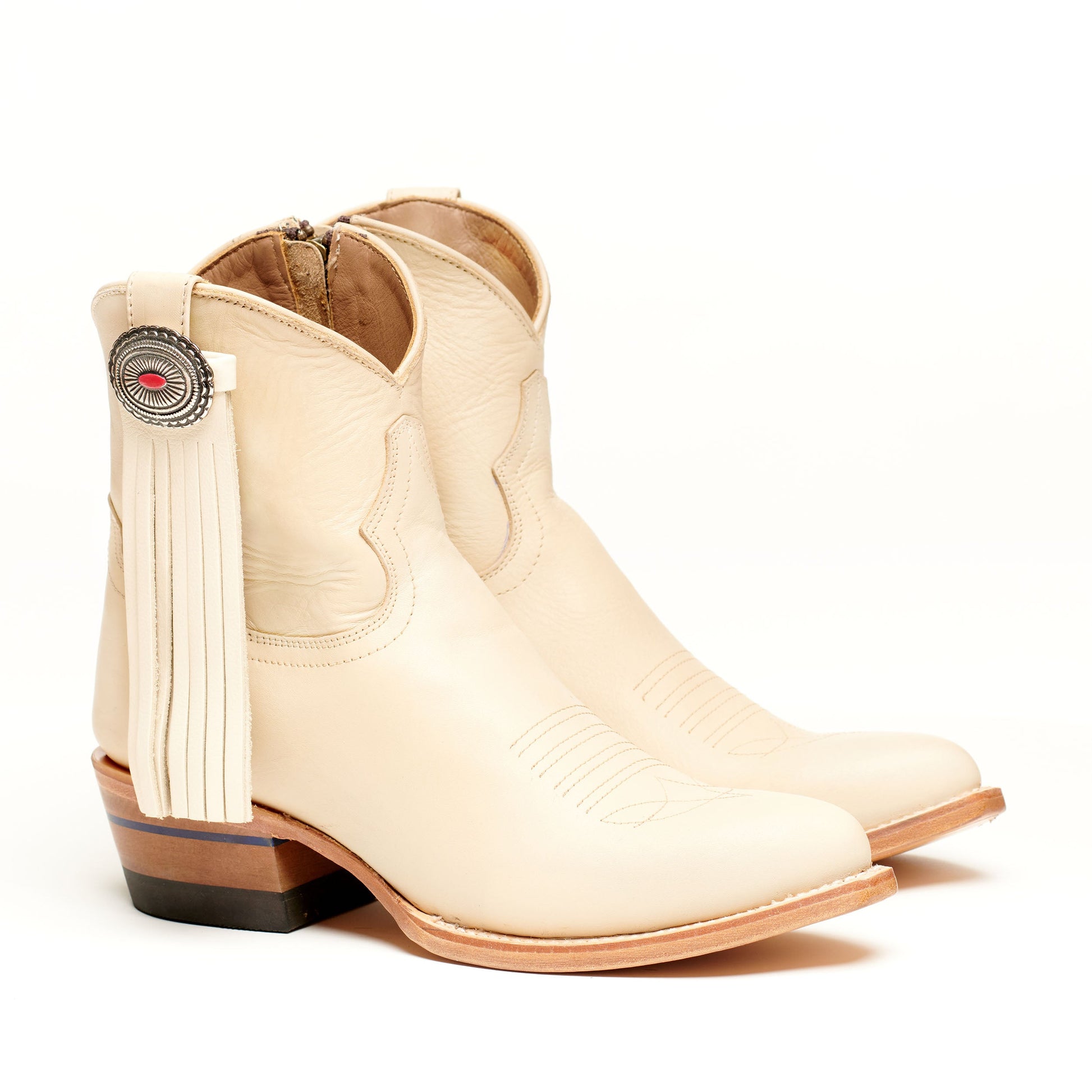 Light tan leather western boot with long tassel fringe and round concho accent