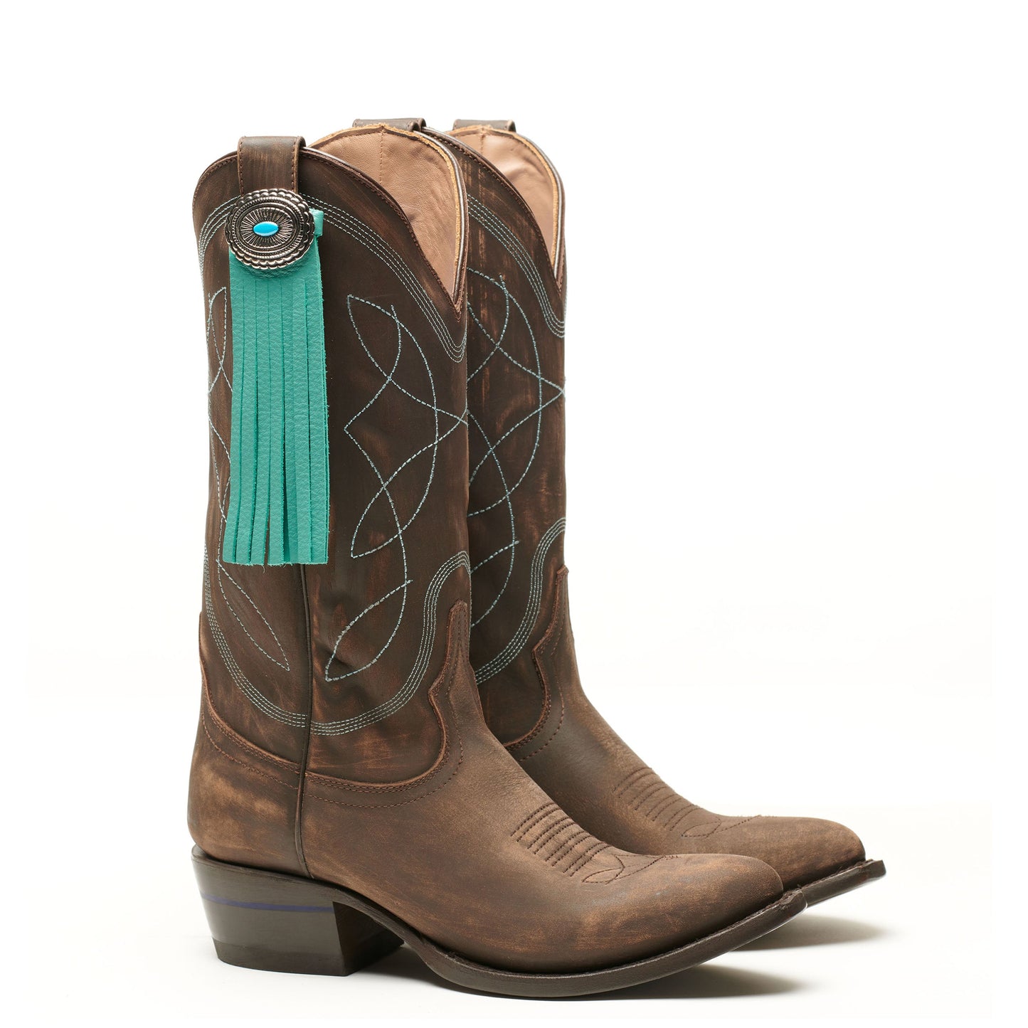 Dark brown cowboy boots with teal fringe tassel and concho medallion
