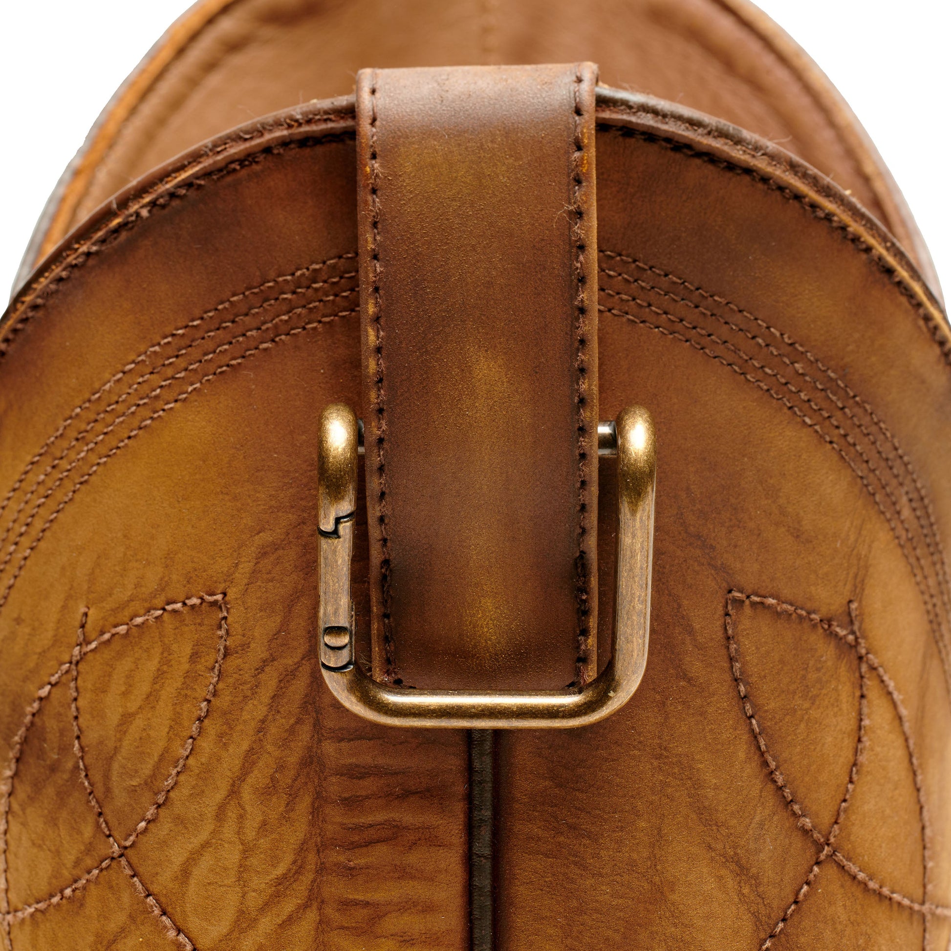 Boot pull clip with gold U-frame on tan leather backing and stitching detail.