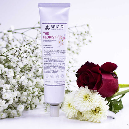 Natural hand lotion tube, white with purple top and front label; flowers below